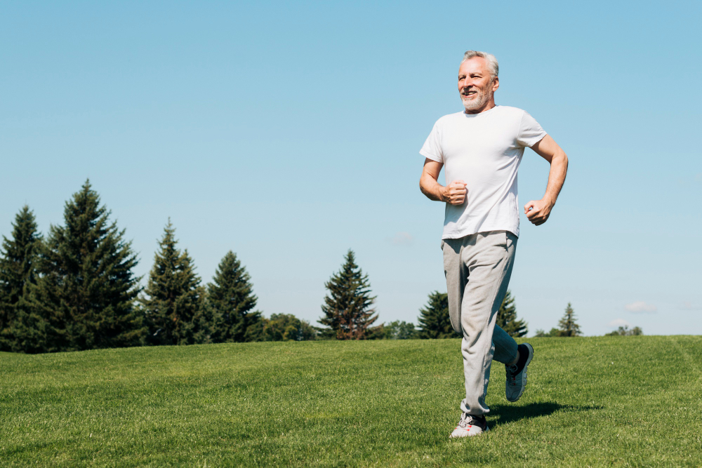 Older individual walking through an open field.